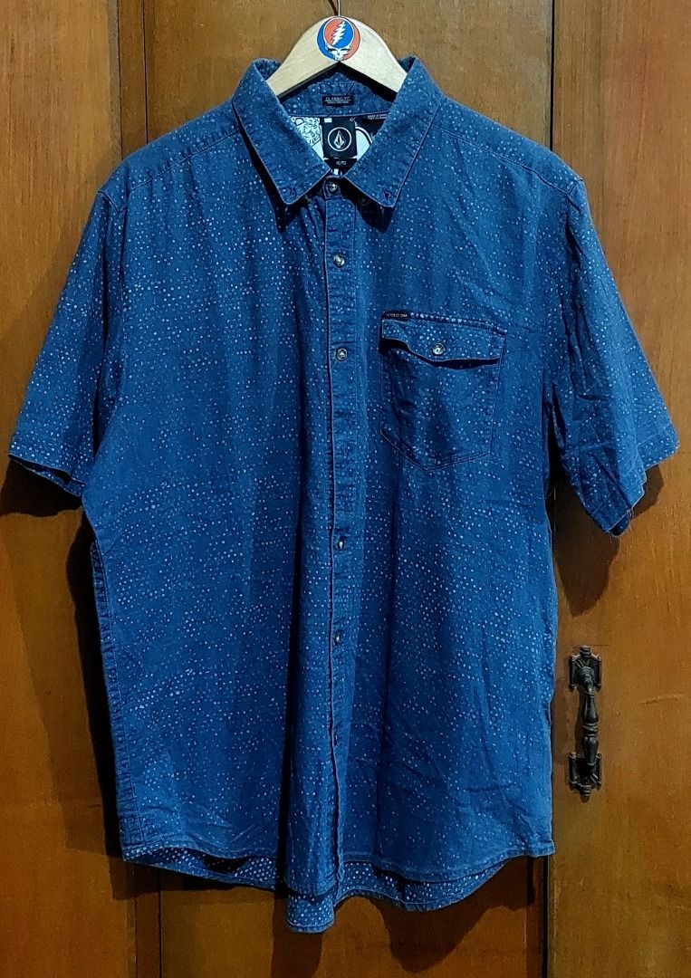 Volcom Blue Short Sleeve Button Down Shirt Size L (Category: Tshirts & Polo Shirts ) located in Legazpi City. Submitted by street_uniform (Listing ID 1470890807, Image 1). Description: - Dimea: W23 L30 - Brand: Volcom - Style: Short-sleeve button-down shirt - Color/Pattern: Blue with all-over white speckled dots - Details: Single chest pocket with flap and brand tag, unique black/white graphic collage on inner collar and yoke - Branding: Iconic e