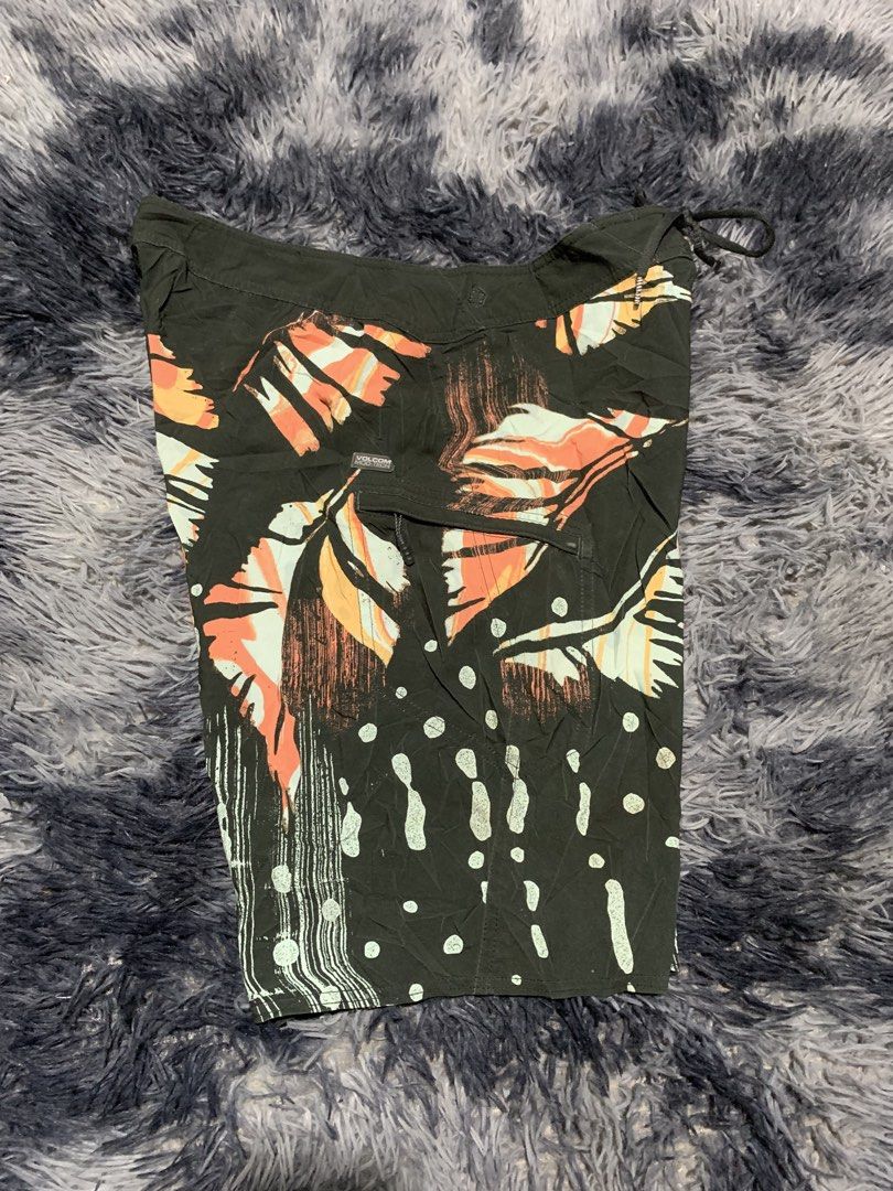 Volcom Mod-Tech Board Shorts Size 33 Black Tropical Leaf Print (Category: Swim Trunks & Board Shorts) located in Tayug. Submitted by cvcthrift (Listing ID 1470895747, Image 2). Description: W-33-34 L-21 NO ISSUE EXCELLENT CR-9.5/10 - Brand: Volcom Mod-Tech - Color: Black with bold tropical leaf and abstract print - Size: 33 (Standard waist with adjustable drawstring) - Features: Secure zippered side pocket with pull tab - Material: Smooth, quick-
