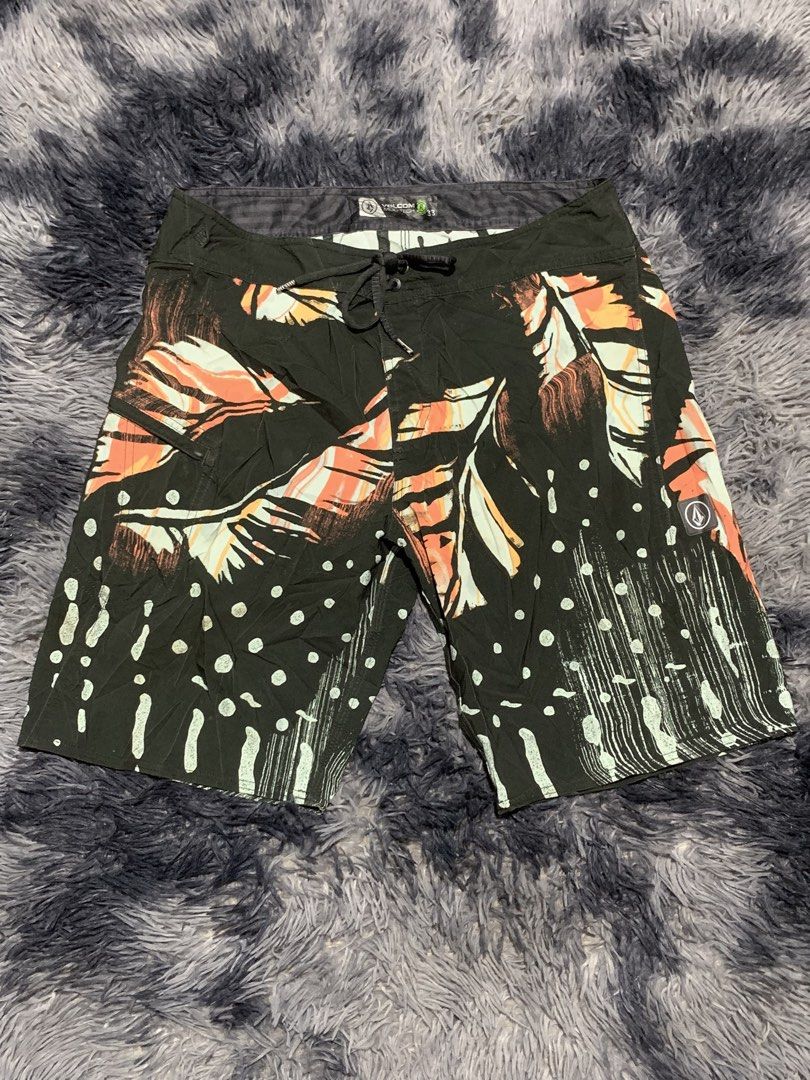 Volcom Mod-Tech Board Shorts Size 33 Black Tropical Leaf Print (Category: Swim Trunks & Board Shorts) located in Tayug. Submitted by cvcthrift (Listing ID 1470895747, Image 3). Description: W-33-34 L-21 NO ISSUE EXCELLENT CR-9.5/10 - Brand: Volcom Mod-Tech - Color: Black with bold tropical leaf and abstract print - Size: 33 (Standard waist with adjustable drawstring) - Features: Secure zippered side pocket with pull tab - Material: Smooth, quick-