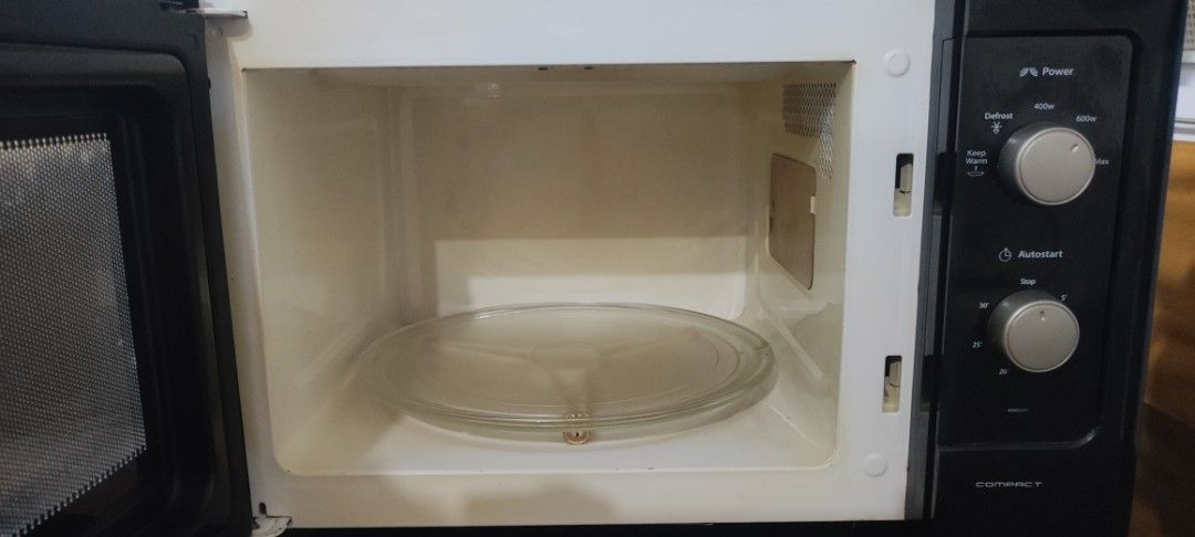 Whirlpool Compact Microwave Oven (Category: Ovens & Toasters) located in Rizal. Submitted by danicahpangilinan (Listing ID 1470822894, Image 3). Description: Black Whirlpool compact microwave oven with a vertical silver handle and dual rotary control knobs on the right panel. Interior cavity includes the rotating glass tray and turntable ring. Standard countertop footprint..