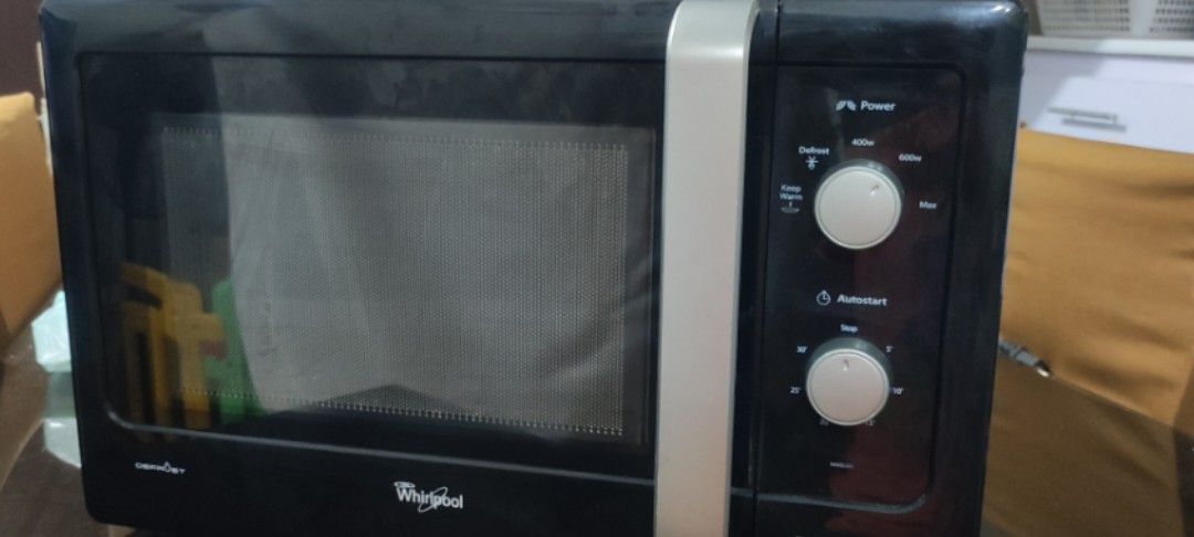 Whirlpool Compact Microwave Oven (Category: Ovens & Toasters) located in Rizal. Submitted by danicahpangilinan (Listing ID 1470822894, Image 1). Description: Black Whirlpool compact microwave oven with a vertical silver handle and dual rotary control knobs on the right panel. Interior cavity includes the rotating glass tray and turntable ring. Standard countertop footprint..