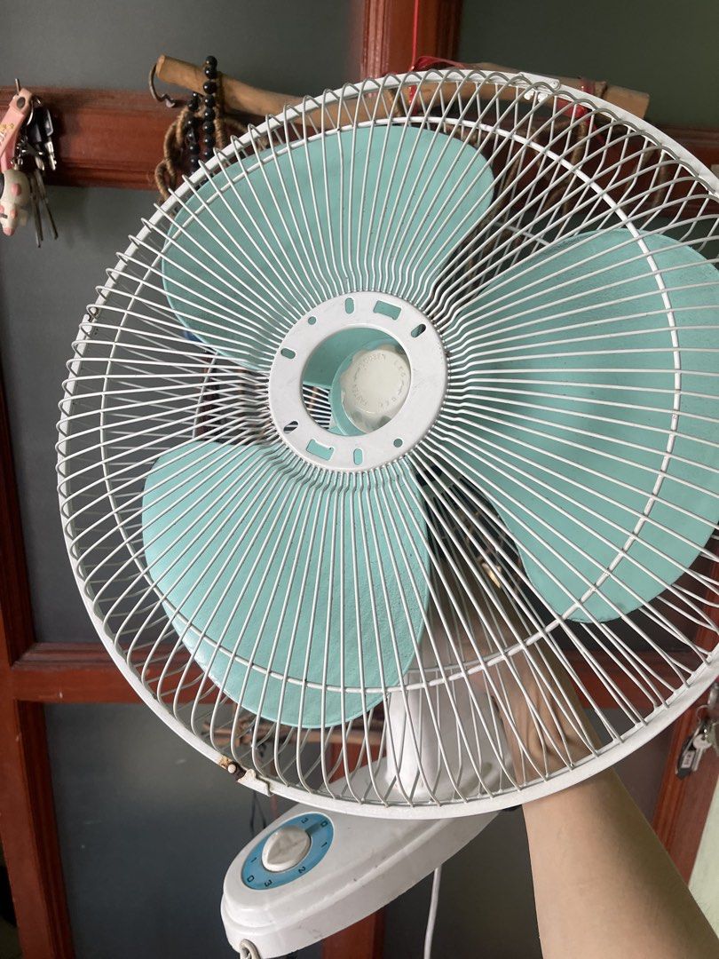White and turquoise wall fan with speed control (Category: Fans) located in Manila. Submitted by pasaybestfinds (Listing ID 1470760967, Image 2). Description: - Type: Wall-mounted electric fan - Color: White body with striking turquoise blades - Speed Control: 3 adjustable speed settings (0-3) - Safety: Sturdy metal wire cage protection - Power: Long cord with standard plug for any wall outlet - Best For: Small rooms, kitchens, offices, and tight
