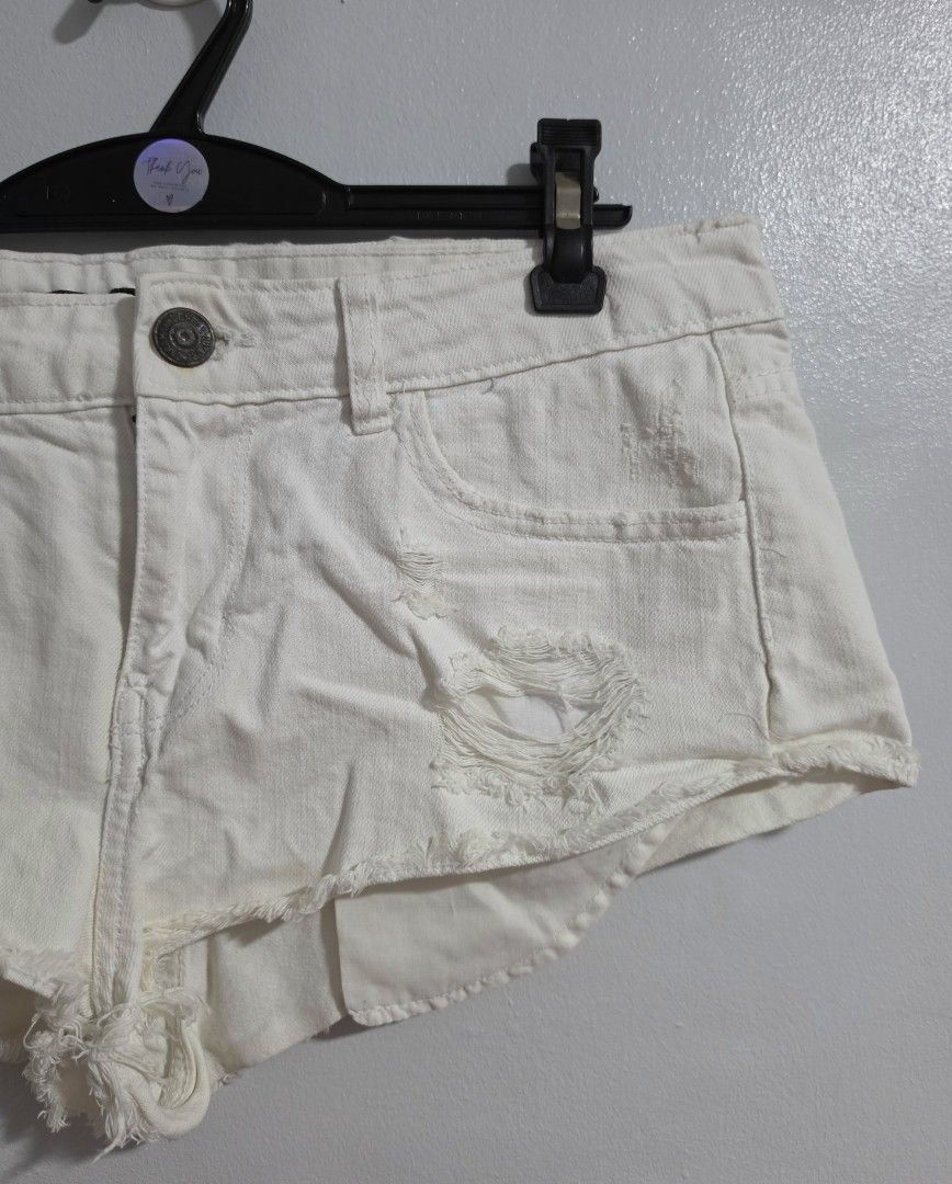 White distressed denim denim micro shorts (Category: Shorts) located in Paranaque City. Submitted by franinnashop (Listing ID 1470850438, Image 2). Description: Decluttr - Style: White denim shorts with heavy distressing and raw frayed hems - Fit: Mid-rise with metallic button closure and zip fly - Measurements (laid flat): Waist 33 inches | Hips 40 inches | Length 10 inches - Condition: Good overall, but please note minor rust stains around the 