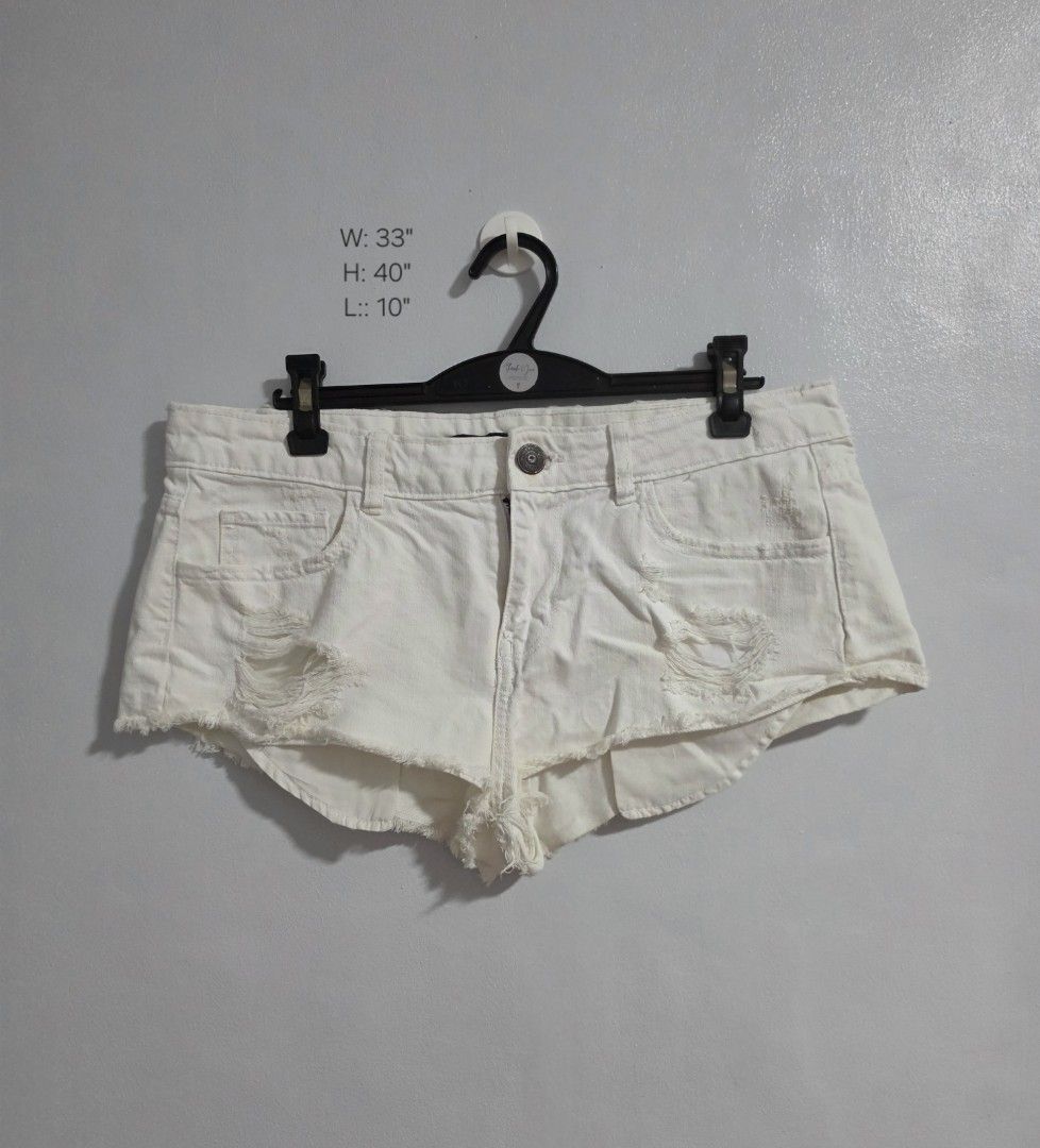 White distressed denim denim micro shorts (Category: Shorts) located in Paranaque City. Submitted by franinnashop (Listing ID 1470850438, Image 1). Description: Decluttr - Style: White denim shorts with heavy distressing and raw frayed hems - Fit: Mid-rise with metallic button closure and zip fly - Measurements (laid flat): Waist 33 inches | Hips 40 inches | Length 10 inches - Condition: Good overall, but please note minor rust stains around the 