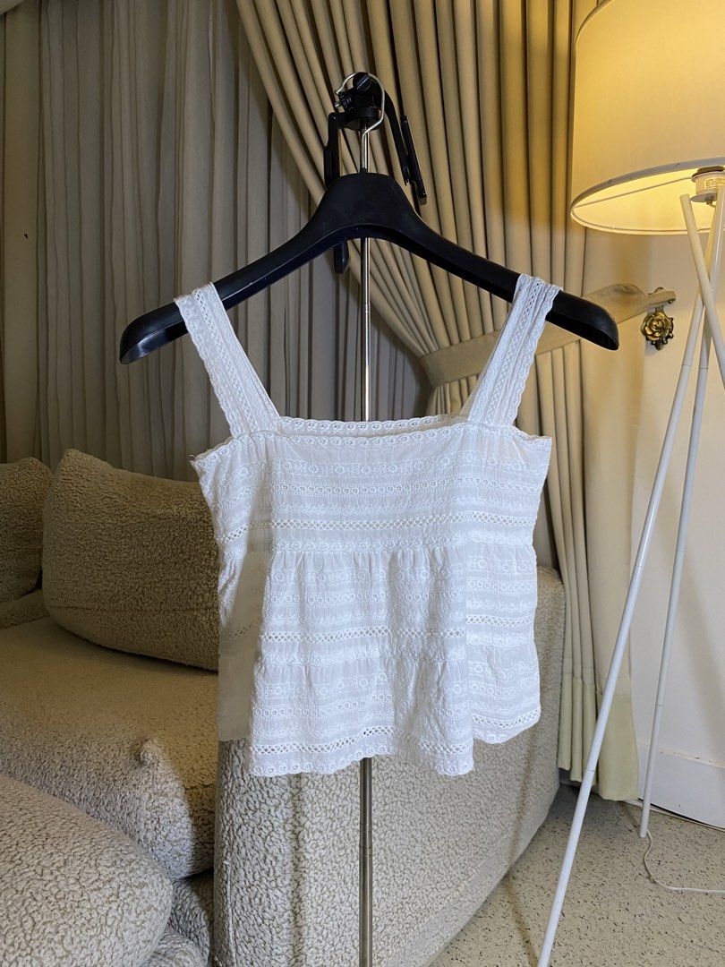 White Eyelet Lace Tank Top Camisole (Category: Sleeveless) located in Valencia. Submitted by negnikkah (Listing ID 1470836292, Image 1). Description: White sleeveless tank top with square neckline and thick straps. Detailed with horizontal bands of eyelet embroidery, floral lace, and cut-out trim patterns. Lightweight woven fabric with a slight tiered gathering below the chest. Scalloped hemline. +SF /J&T.