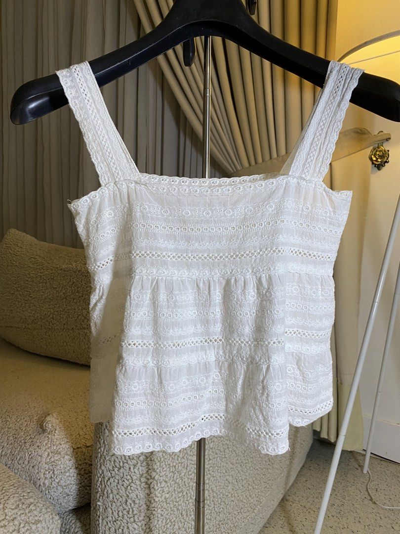 White Eyelet Lace Tank Top Camisole (Category: Sleeveless) located in Valencia. Submitted by negnikkah (Listing ID 1470836292, Image 2). Description: White sleeveless tank top with square neckline and thick straps. Detailed with horizontal bands of eyelet embroidery, floral lace, and cut-out trim patterns. Lightweight woven fabric with a slight tiered gathering below the chest. Scalloped hemline. +SF /J&T.