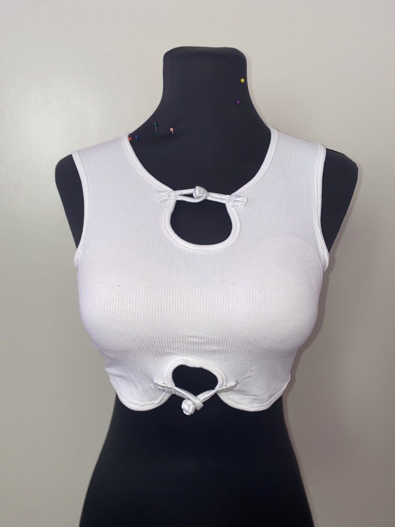 White Ribbed Crop Top with Cutout Detailing (Category: Sleeveless) located in Pasay City. Submitted by violetttttttttttttt (Listing ID 1470821285, Image 1). Description: - Color: White - Style: Sleeveless, scoop neckline, curved hem, cropped and fitted cut - Details: Front keyhole cutouts with Chinese knot button closures, plain back - Material: Stretchy ribbed knit - Versatility: Easy to match with high-waisted jeans or skirts.
