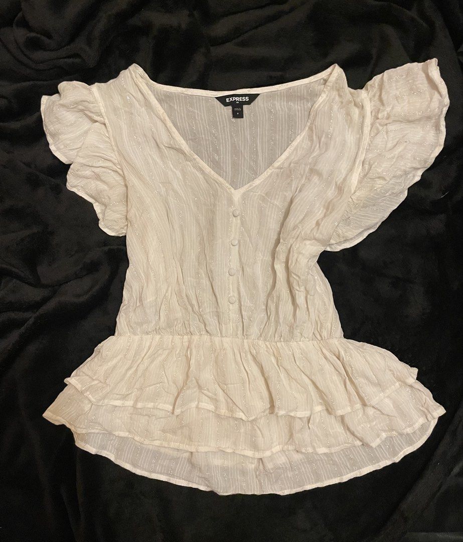 White Ruffle Short Sleeve Peplum Top Size S (Category: Blouses) located in Bacolod City. Submitted by angelsantii (Listing ID 1470925675, Image 1). Description: - Brand: Express - Size: Small - Color: White with subtle metallic stripes - Neckline: V-neck with a 4-button placket - Sleeves: Short flutter ruffles - Hem: Multi-tiered layered ruffle - Waist: Cinched elastic waist - Material: Lightweight and comfortable.