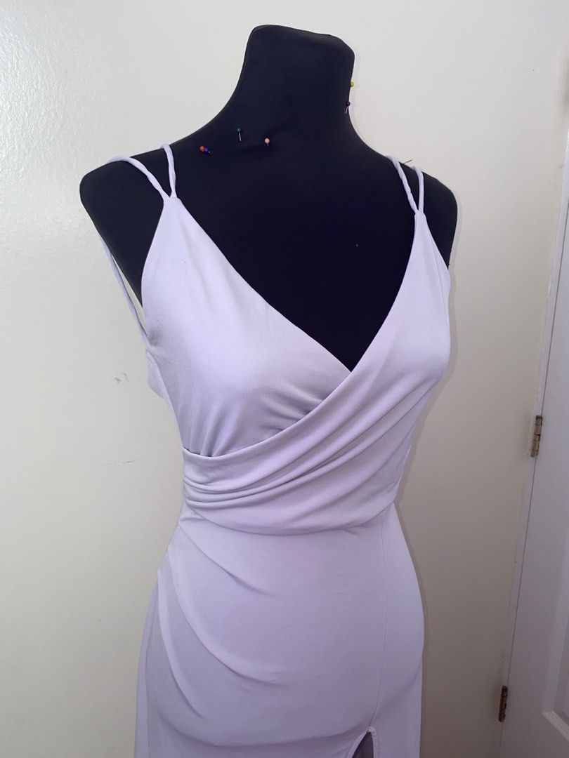 White V-neck wrap maxi dress with double straps (Category: Dresses) located in Pasay City. Submitted by violetttttttttttttt (Listing ID 1470822315, Image 3). Description: White sleeveless maxi dress. Features a crossover V-neck wrap bodice and double spaghetti straps. Back includes a low scoop cut and a hidden zipper closure down the center. Front has a high center slit starting at the thigh. Long floor-length hem with slight pooling..