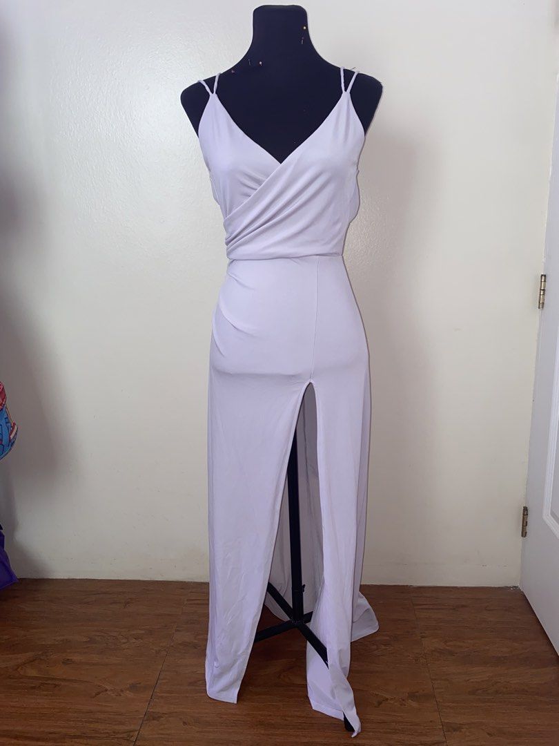White V-neck wrap maxi dress with double straps (Category: Dresses) located in Pasay City. Submitted by violetttttttttttttt (Listing ID 1470822315, Image 2). Description: White sleeveless maxi dress. Features a crossover V-neck wrap bodice and double spaghetti straps. Back includes a low scoop cut and a hidden zipper closure down the center. Front has a high center slit starting at the thigh. Long floor-length hem with slight pooling..