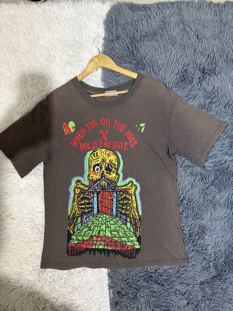 Yeezy x XXXTentacion Hold the Gate (Category: Tshirts & Polo Shirts ) located in Manila. Submitted by keepercollection (Listing ID 1470830713, Image 1). Description: - Brand: HLUT - Size: Medium - Color: Brown - Design: Bold skull, gateway, and reaper graphics with "WHEN I'M ON THE WAY HOLD THE GATE" and "SHE WANT TO GIVE YOU THE COOKIE" text - Fit: Short sleeves, standard crew neck - Condition: Minor cracking on screen print (refer to close-up p