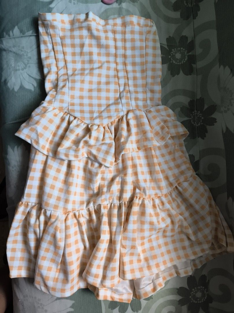 Yellow and white gingham check strapless ruffled mini dress (Category: Dresses) located in Bulacan. Submitted by jvblaguard08460 (Listing ID 1470754809, Image 3). Description: - Pattern: Yellow and white gingham check - Design: Strapless with layered ruffles on front and bottom hem - Material: Lightweight and breathable fabric, ideal for warm weather - Fit: Easy pullover style (no zippers or straps).