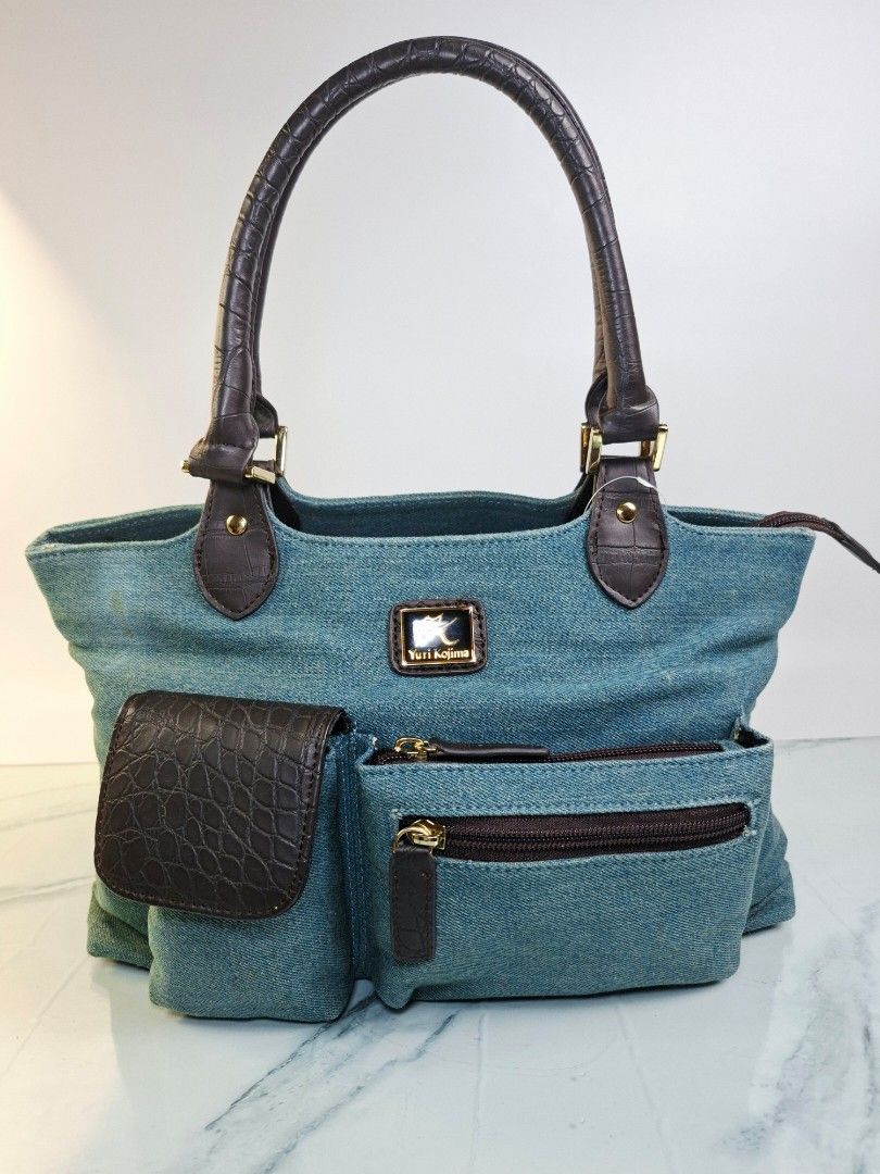 Yuri Kojima Denim and Crocodile Pattern Handbag (Category: Tote Bags) located in Pasay City. Submitted by onick_79 (Listing ID 1470917813, Image 1). Description: -Dimensions L31 x H22 x W14 cm - Brand: Yuri Kojima - Material: Blue denim with dark brown faux crocodile trim - Closure: Secure top zip closure - Pockets: Multiple exterior pockets for easy organization - Hardware: Gold-tone hardware with front brand logo plaque - Design: Double handle,