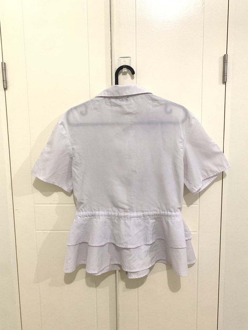 Zalora Collection White Peplum Blouse Size S (Category: Blouses) located in Pasig City. Submitted by lovedbyri (Listing ID 1470861612, Image 3). Description: - Brand: Zalora Collection - Item: White button-down blouse - Size: Small - Features: Short sleeves, lapel collar, and adjustable drawstring waist with double-layered ruffles - Condition: Pre-loved with faint smudge marks and dirt stains on the upper back area - Perfect for smart-casual offi