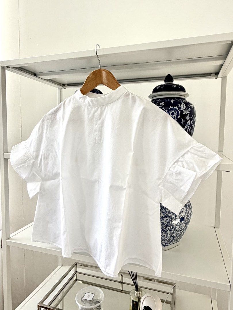 Zara Basic White Ruffle Sleeve Blouse (Category: Blouses) located in Lipa City. Submitted by pauline0303 (Listing ID 1470802623, Image 2). Description: - Brand: Zara Basic - Size: S - Origin: Made in Morocco - Color: Classic White - Fit: Boxy and relaxed - Details: High neckline with back button closure - Sleeves: Short sleeves with cute ruffled flare cuffs - Styling: Versatile basic piece, perfect to match with jeans or skirts - 1 missing middle