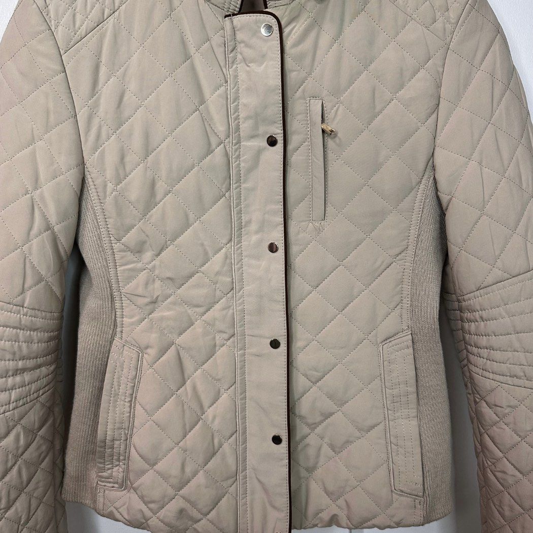 ZARA Beige Diamond Quilted Fitted Jacket (Size S) (Category: Coats, Jackets and Outerwear) located in Baguio. Submitted by lctrendz (Listing ID 1470869463, Image 3). Description: Quilted polyester jacket. Diamond pattern quilting, high neck collar with snap closure, full-length front zip with snap placket, and ribbed side panels for a fitted silhouette. Fully lined. Brand: ZARA Color: Beige Condition: Excellent Condition Size: Small Measurements 