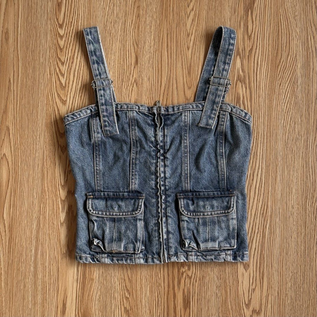 Zara Denim Corset Crop Top (Category: Sleeveless) located in Calamba. Submitted by quietarchive (Listing ID 1470820653, Image 2). Description: - Brand: Zara - Size: XS - Style: Denim corset crop top in classic blue wash - Closure: Convenient front zipper - Details: Two front cargo pockets and adjustable buckle straps - Fit: Smocked back panel for extra stretch and comfort.