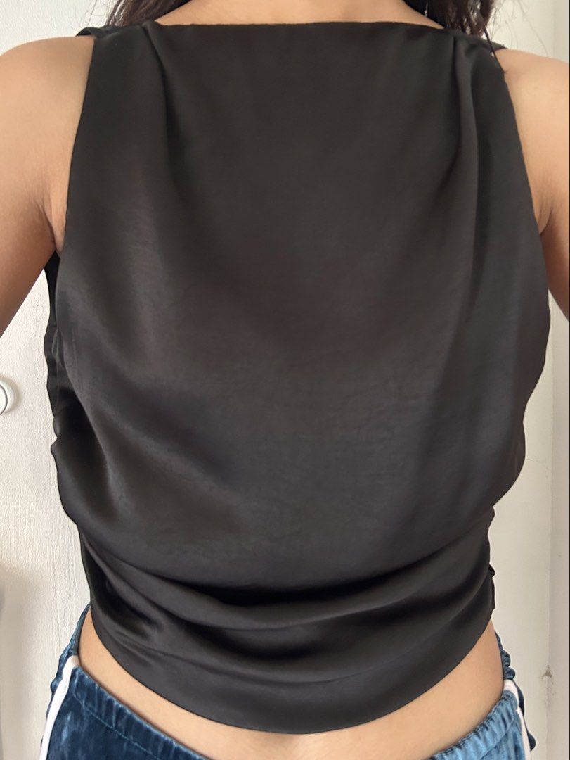 ZARA Draped Top with Back Tie in Black (Category: Sleeveless) located in Batangas. Submitted by wearmegals (Listing ID 1470817483, Image 3). Description: - Color: Sleek black with a subtle, elegant sheen - Material: Lightweight, premium silk-like fabric - Neckline: High neck with gentle front gathering - Details: Flattering side ruching along the length - Back: Trendy deep V-cut with a large fabric tie at the hem - Style: Sleeveless, chic, and ve