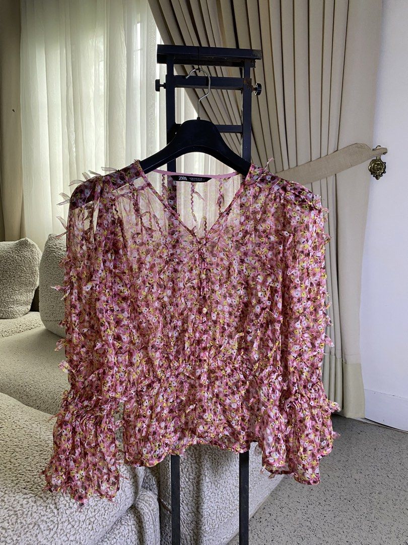 Zara Pink Floral Textured Ruffle Blouse (Category: Blouses) located in Valencia. Submitted by negnikkah (Listing ID 1470820072, Image 2). Description: - Brand: Zara - Size: Medium (M) - Design: Pink floral print with unique all-over frayed texture - Neckline: V-neck with front buttons - Sleeves: Tiered bell sleeves - Fabric: Lightweight and flowy, very comfortable to wear - Condition: Excellent / Like new.