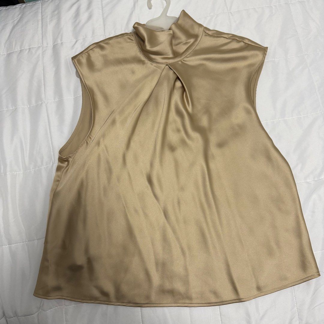 Zara Satin Sleeveless Mock Neck Top (Category: Sleeveless) located in Makati City. Submitted by angela.pm (Listing ID 1470778938, Image 1). Description: - Brand: Zara - Size: M (fits true to size) - Color/Material: Gold satin, made in Turkey - Design: Sleeveless, mock neck - Fit: Relaxed fit, drapes nicely - Condition: Great pre-loved condition - Styling: Versatile neutral piece, perfect for work or going out, easily paired with trousers or a ski