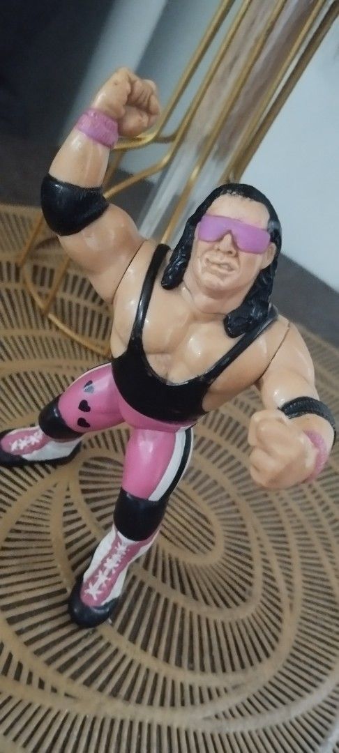 1990 Hasbro WWF Bret "The Hitman" Hart (Category: Action & Battle Toys) located in Manila. Submitted by ventajetoyz625 (Listing ID 1470954471, Image 1). Description: - Vintage WWF Hasbro Bret Hart action figure - Features his iconic pink and black singlet with heart details and pink sunglasses - Right arm sculpted in his signature pose - Condition: Shows minor paint wear on boots and hair due to age and play - Ideal for retro wrestling fans and v