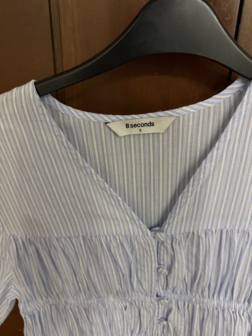8 seconds Blue Striped V-Neck Blouse Size S (Category: Blouses) located in Quezon City. Submitted by prettyme23 (Listing ID 1470938065, Image 3). Description: - Brand: 8 Seconds - Color: Light blue and white stripes - Size: S (fits true to size) - Design: V-neckline, front button closure, and gathered smocked bodice - Material: Lightweight fabric ideal for warm weather - Styling: Easily pairs with jeans or skirts.
