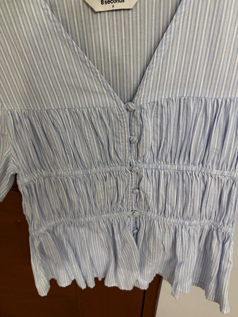 8 seconds Blue Striped V-Neck Blouse Size S (Category: Blouses) located in Quezon City. Submitted by prettyme23 (Listing ID 1470938065, Image 2). Description: - Brand: 8 Seconds - Color: Light blue and white stripes - Size: S (fits true to size) - Design: V-neckline, front button closure, and gathered smocked bodice - Material: Lightweight fabric ideal for warm weather - Styling: Easily pairs with jeans or skirts.