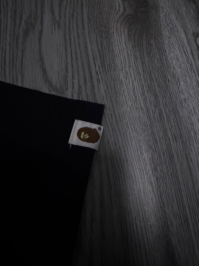 A Bathing Ape BAPE Camo Ape Head Tee (Category: Tshirts & Polo Shirts ) located in Manila. Submitted by yourfavoriteplug (Listing ID 1471054998, Image 3). Description: - Brand: BAPE (A Bathing Ape) - Item: Classic Camo Ape Head T-Shirt - Color: Black with blue, yellow, and white graphic - Size: Large - Material: 100% Cotton - Origin: Made in Japan - Condition: Good, with minor cracking on the front print (see close-up) - Details: Sleeve tag attac