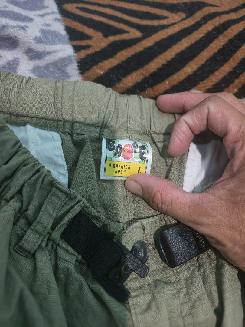 A Bathing Ape BAPE Green Cargo Shorts Size L (Category: Shorts) located in Caloocan City. Submitted by cccccc333888 (Listing ID 1471052097, Image 3). Description: - Brand: A Bathing Ape (BAPE) - Item: Green cargo shorts - Size: Large - Details: Built-in adjustable black web belt with plastic buckle and elastic waistband - Branding: Small embroidered ape logo near the bottom hem - Condition/Build: Clean fabric construction with reinforced stitchin