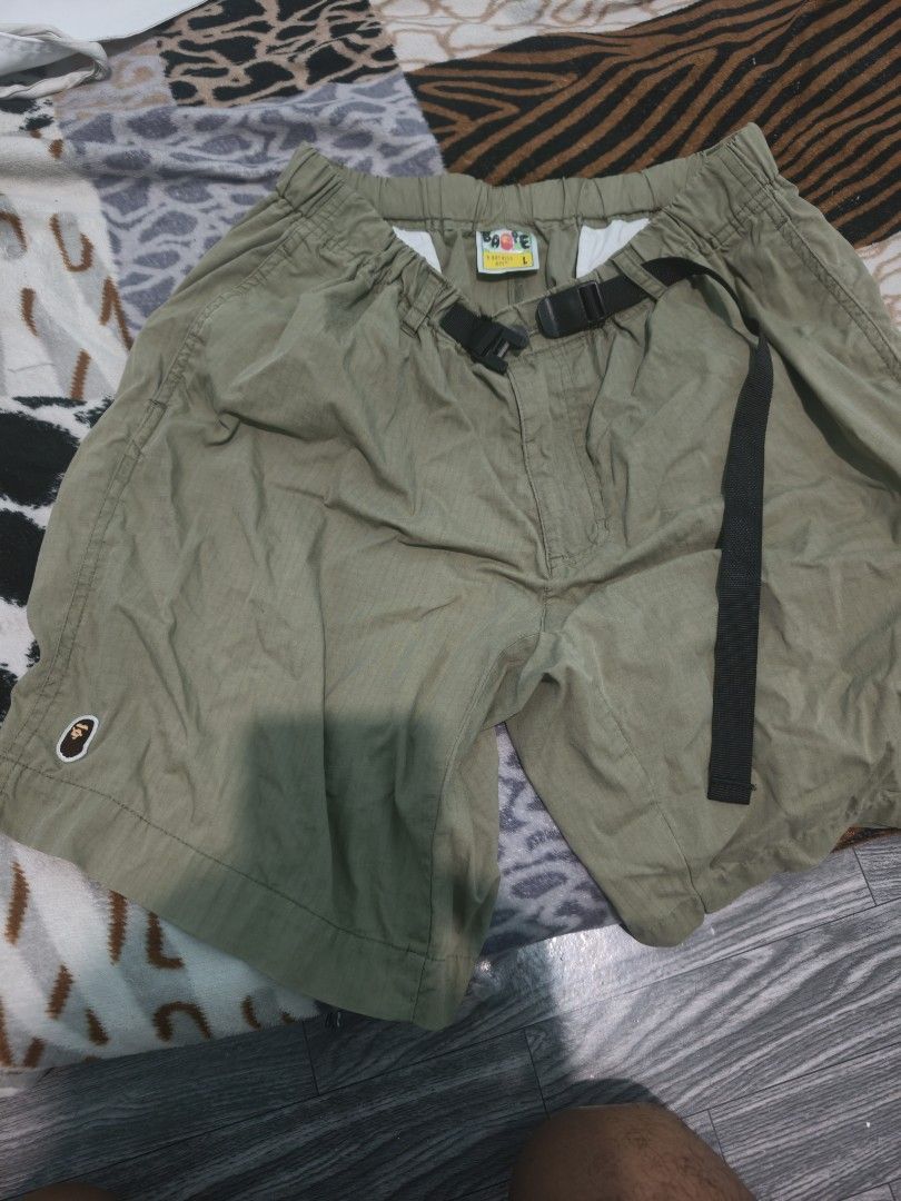 A Bathing Ape BAPE Green Cargo Shorts Size L (Category: Shorts) located in Caloocan City. Submitted by cccccc333888 (Listing ID 1471052097, Image 1). Description: - Brand: A Bathing Ape (BAPE) - Item: Green cargo shorts - Size: Large - Details: Built-in adjustable black web belt with plastic buckle and elastic waistband - Branding: Small embroidered ape logo near the bottom hem - Condition/Build: Clean fabric construction with reinforced stitchin