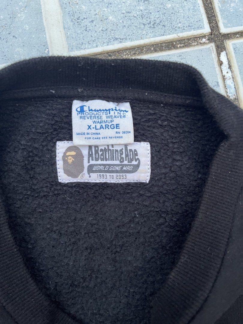A Bathing Ape x Champion Black Reverse Weave Sweatshirt (Category: Coats, Jackets and Outerwear) located in Leyte. Submitted by odd_noodle (Listing ID 1470988224, Image 3). Description: - Brand: BAPE x Champion - Item: Reverse Weave Sweatshirt - Color: Black - Size: XL - Details: Classic Champion script logo embroidery on chest - Back Graphic: Giant A Bathing Ape head print - Accents: Collaborative woven labels at neckline and sleeve cuff - Mater