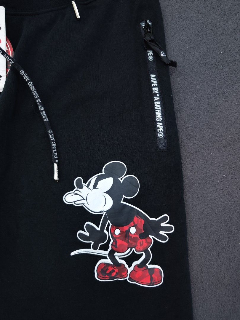 Aape X Mickey Mouse Jogger (Category: Joggers) located in Bulacan. Submitted by emilj23 (Listing ID 1470972190, Image 2). Description: Aape X Mickey Mouse Jogger Size L on tag L 36 W 30-36 Leg Hole 4 Condition 9.5/10 Color rate 9.5/10 Issue Missing Patch,Broken Zipper.