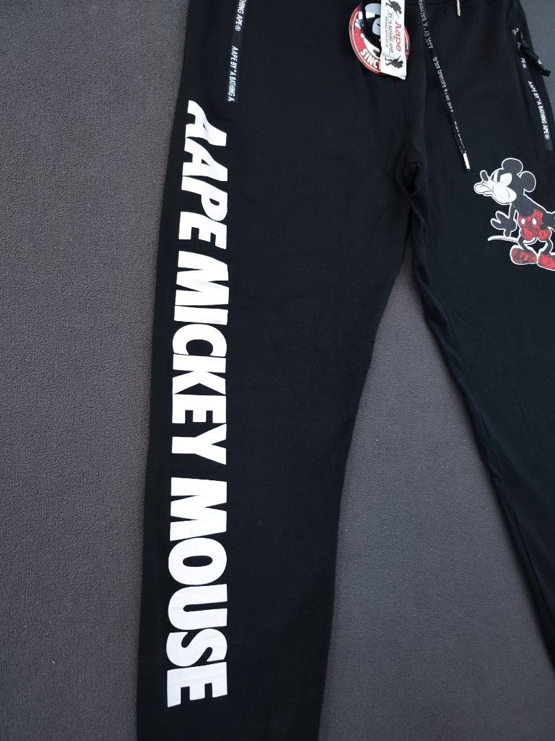 Aape X Mickey Mouse Jogger (Category: Joggers) located in Bulacan. Submitted by emilj23 (Listing ID 1470972190, Image 3). Description: Aape X Mickey Mouse Jogger Size L on tag L 36 W 30-36 Leg Hole 4 Condition 9.5/10 Color rate 9.5/10 Issue Missing Patch,Broken Zipper.