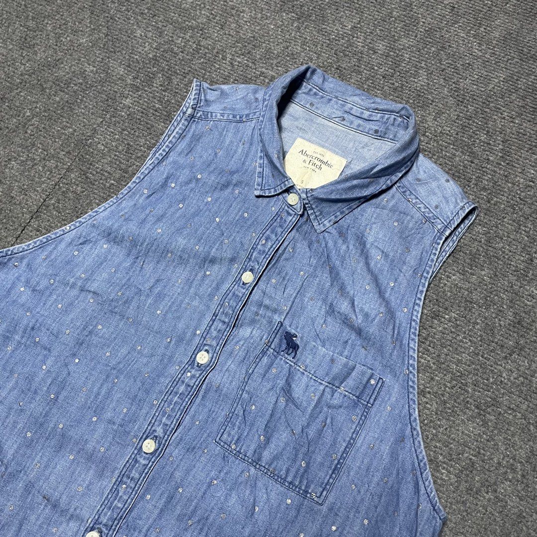 Abercrombie & Fitch moose logo. (Category: Blouses) located in Iloilo. Submitted by 3ift2heav3n (Listing ID 1471073107, Image 3). Description: Abercrombie & Fitch moose logo women's sleeveless denim/chambray button-down shirt with a small polka-dot or dash pattern and a left chest pocket. Authentic Small Excellent condition Waistline 17 Lenght 27.