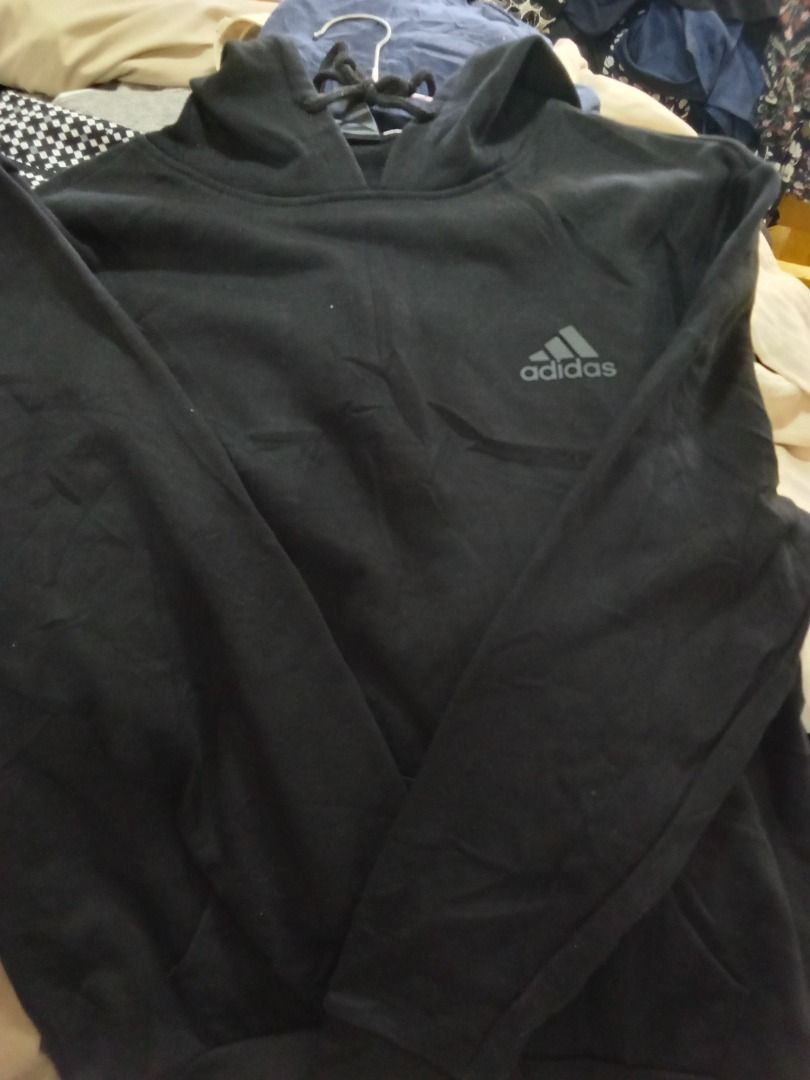 Adidas Black Hoodie with Drawstrings (Category: Hoodies) located in Caloocan City. Submitted by rajjuuu (Listing ID 1470977012, Image 3). Description: - Color: Black - Design: Classic pullover with iconic Adidas logo on the chest - Comfort: Soft fleece lining inside for extra warmth - Hood: Adjustable drawstrings with durable metal tips - Storage: Convenient front kangaroo pocket - Sleeves: Long sleeves for all-day comfort.
