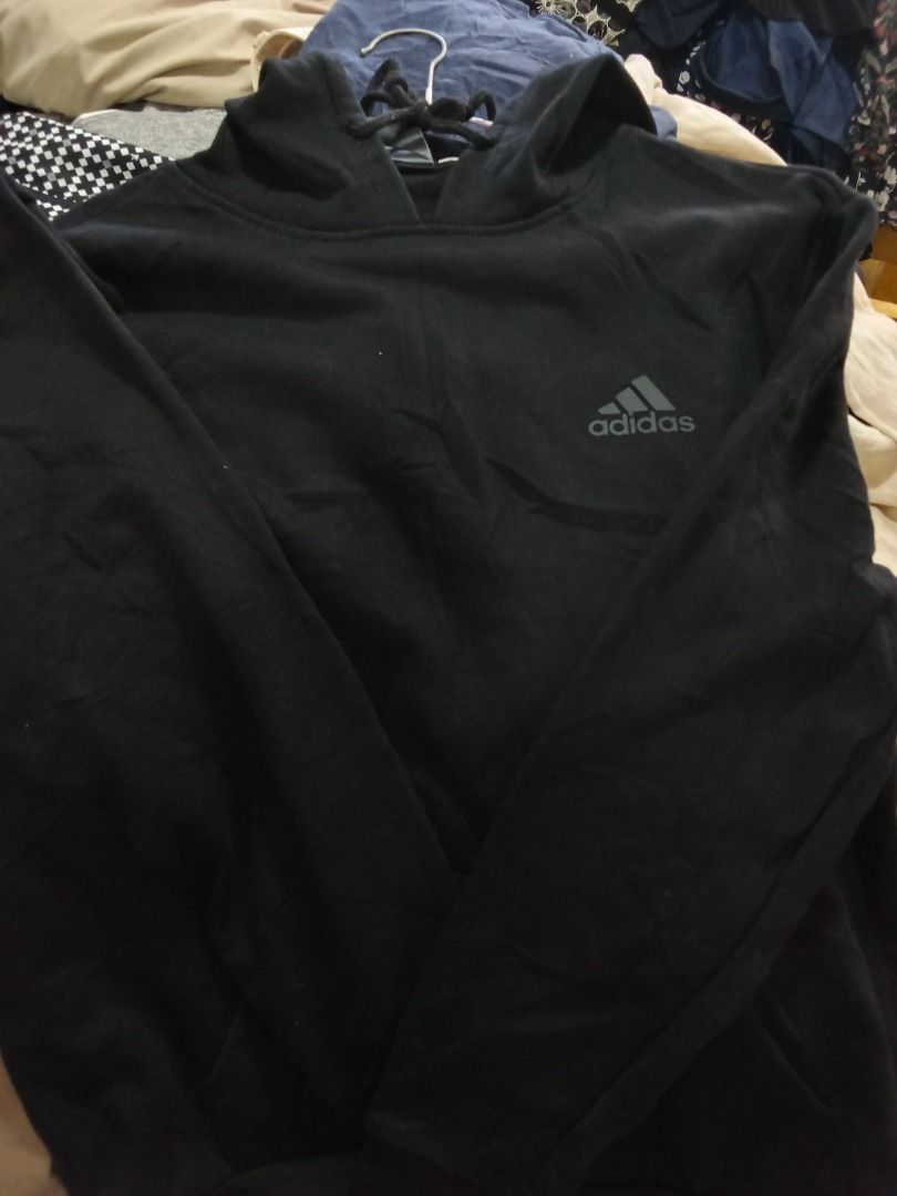 Adidas Black Hoodie with Drawstrings (Category: Hoodies) located in Caloocan City. Submitted by rajjuuu (Listing ID 1470977012, Image 2). Description: - Color: Black - Design: Classic pullover with iconic Adidas logo on the chest - Comfort: Soft fleece lining inside for extra warmth - Hood: Adjustable drawstrings with durable metal tips - Storage: Convenient front kangaroo pocket - Sleeves: Long sleeves for all-day comfort.
