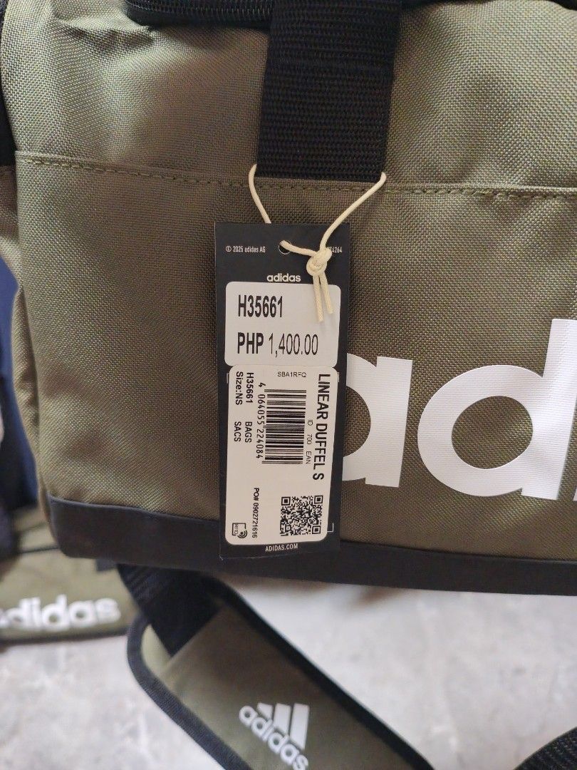 Adidas Linear Duffel Bag Small Olive Green (Category: Sling Bags) located in Manila. Submitted by ggclothings (Listing ID 1470972603, Image 2). Description: - Brand new with original tags attached (Model: H35661) - Color: Olive green with a striking white Adidas logo on the front - Size: Small, perfect for the gym, sports, or overnight trips - Comfortable carry: Dual hand straps plus a long adjustable shoulder strap with a padded cushion - Durabl