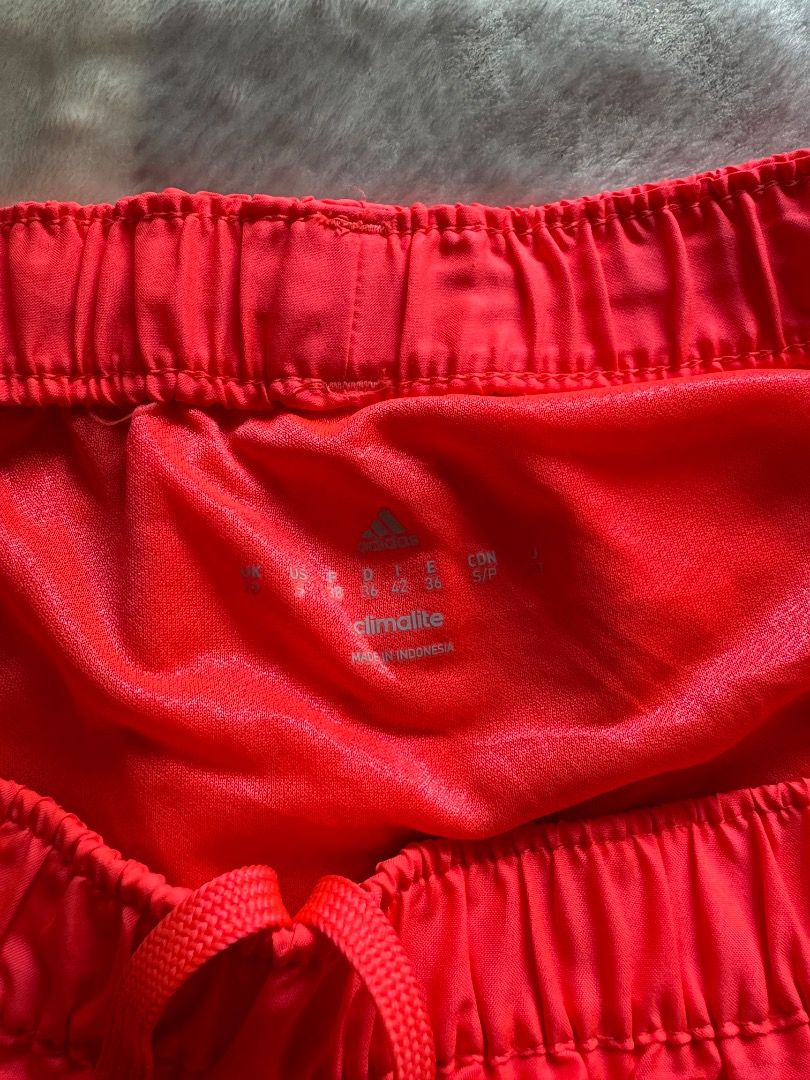 Adidas Red Athletic Running Shorts (Category: Shorts) located in Danao, Cebu. Submitted by kentoy25 (Listing ID 1471007664, Image 3). Description: - Brand: Adidas - Color: Bright red with white logo on the hem - Fit: Elastic waistband with adjustable drawstring - Comfort: Lightweight fabric with built-in inner lining - Condition: Clean interior tag, ready to wear - Ideal for: Workouts, running, and daily activewear.