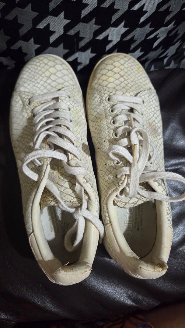 Adidas Stan Smith White Snakeskin Sneakers (Category: Sneakers) located in Quezon City. Submitted by kctheexplorer05 (Listing ID 1471099073, Image 2). Description: - Brand: Adidas Stan Smith - Design: Off-white faux snakeskin pattern, classic low-top court shoe - Condition: Pre-loved with noticeable yellowing and minor scuffs on the upper - Soles: Shows dirt accumulation from regular use - Flaws: Peeling material on the right shoe's heel collar &