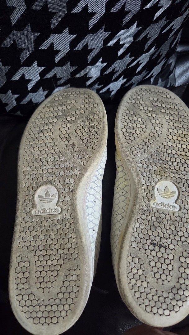 Adidas Stan Smith White Snakeskin Sneakers (Category: Sneakers) located in Quezon City. Submitted by kctheexplorer05 (Listing ID 1471099073, Image 3). Description: - Brand: Adidas Stan Smith - Design: Off-white faux snakeskin pattern, classic low-top court shoe - Condition: Pre-loved with noticeable yellowing and minor scuffs on the upper - Soles: Shows dirt accumulation from regular use - Flaws: Peeling material on the right shoe's heel collar &