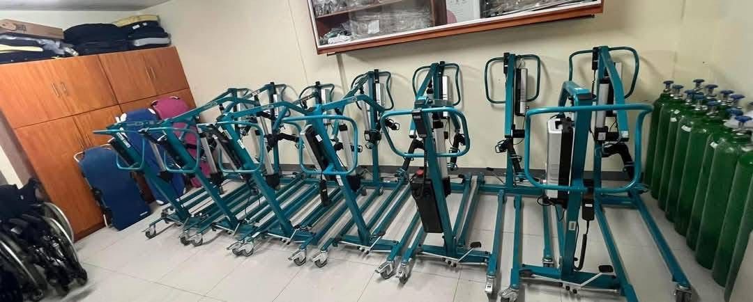 AKS Patient Lift Mobility Hoist (Category: Medical Supplies & Tools) located in Manila. Submitted by calmdolphin.87b0e4 (Listing ID 1470954903, Image 2). Description: - Color: Teal blue frame - Power: Electric actuator with handheld controller and rechargeable battery - Mobility: Heavy-duty locking caster wheels for safety - Inclusions: Padded sling included - Condition/Stock: Brand new/Multiple units available in storage - Ideal for: Safe patien
