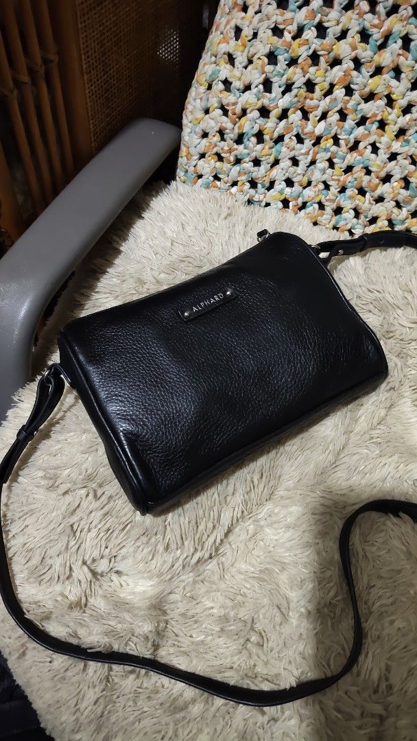Alphard Black Leather Crossbody Bag (Category: Cross-body Bags) located in Cebu City. Submitted by lumaynojes00490 (Listing ID 1470998754, Image 3). Description: - Brand: Alphard - Material: Premium black pebbled leather - Hardware: Sleek silver-tone hardware with front metal logo badge - Compartments: Secure top zip closure, clean interior lining, and a zippered back pocket with a stylish leather tassel pull - Strap: Adjustable shoulder strap fo