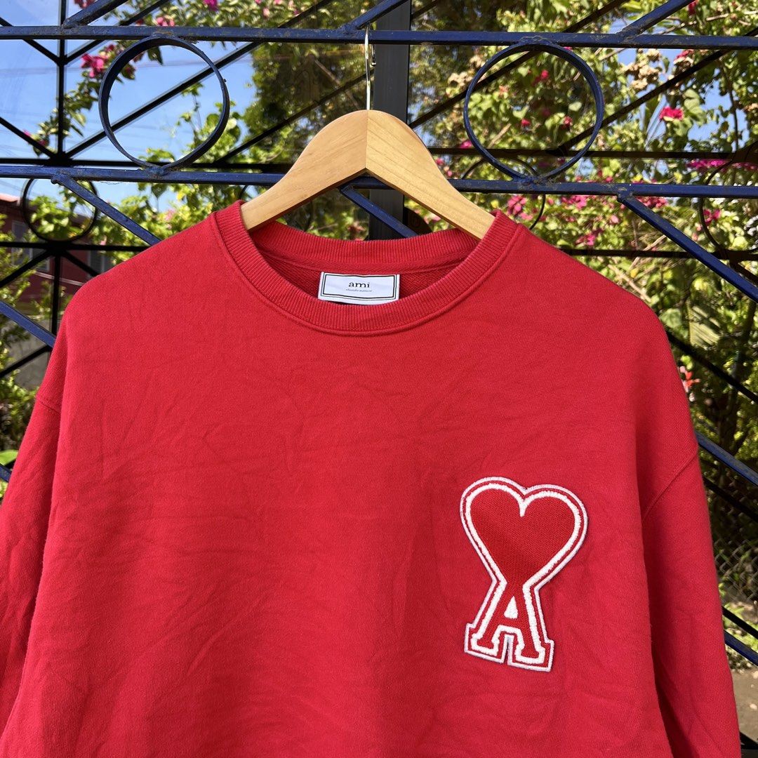 Ami Paris Red Heart Logo Sweatshirt (Category: Coats, Jackets and Outerwear) located in Davao. Submitted by streetsight (Listing ID 1471021408, Image 2). Description: - Brand: Ami Paris by Alexandre Mattiussi - Color: Vibrant red with large white embroidered heart logo on chest - Material: 100% premium cotton (Made in Portugal) - Design: Classic crewneck pullover with ribbed collar, cuffs, and hem - Condition: Excellent, ready to wear - Perfect f