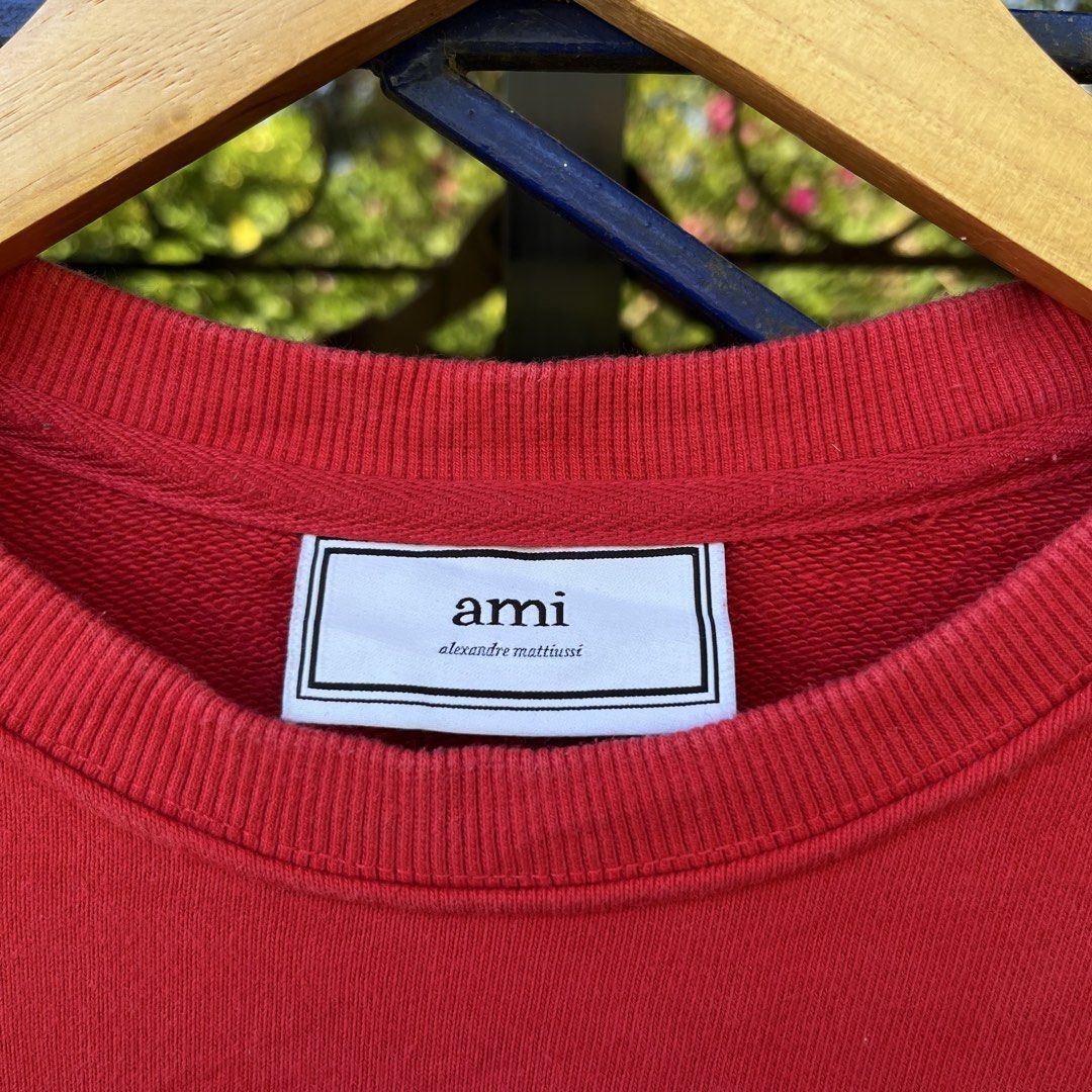 Ami Paris Red Heart Logo Sweatshirt (Category: Coats, Jackets and Outerwear) located in Davao. Submitted by streetsight (Listing ID 1471021408, Image 3). Description: - Brand: Ami Paris by Alexandre Mattiussi - Color: Vibrant red with large white embroidered heart logo on chest - Material: 100% premium cotton (Made in Portugal) - Design: Classic crewneck pullover with ribbed collar, cuffs, and hem - Condition: Excellent, ready to wear - Perfect f