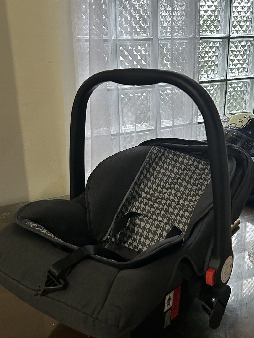 Apruva Infant Car Seat Grey Houndstooth (Category: Car Seats) located in Manila. Submitted by jovy_mae (Listing ID 1470996980, Image 1). Description: - Brand: Apruva Baby Car Seat - Color/Design: Chic grey with a trendy houndstooth pattern cushion - Safety: Built-in harness straps, central buckle, safety certification labels, and side airbag warning sticker - Convenience: Adjustable carry handle with red release buttons on both sides and an attac