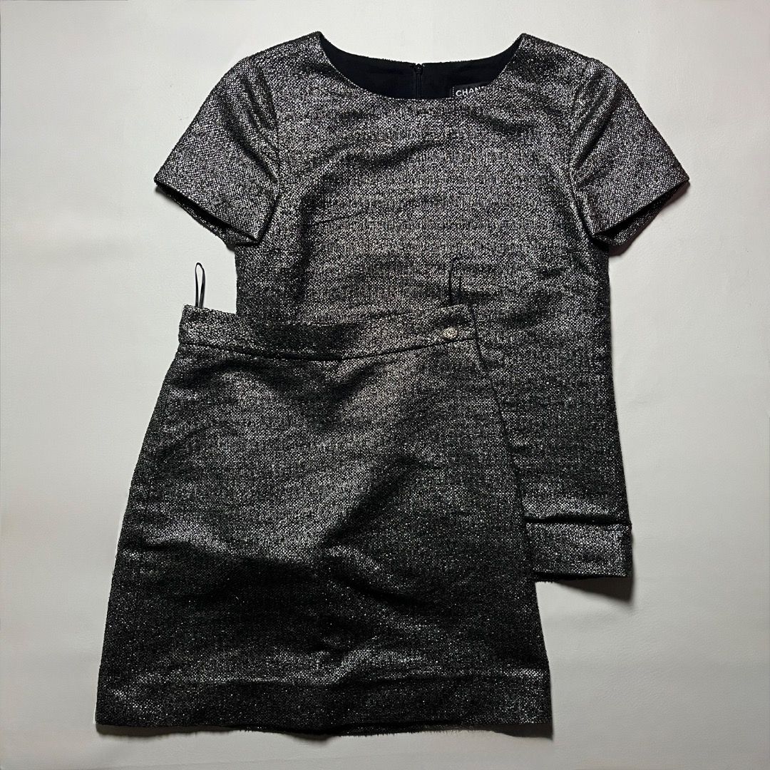 Authentic Chanel Metallic Black Two-Piece Skirt Set (Category: Sets or Coordinates) located in Caloocan City. Submitted by achilles_grails (Listing ID 1471056494, Image 1). Description: - Brand: Chanel - Type: Matching set (Short-sleeve top & wrap mini skirt) - Color: Metallic black with textured glitter finish - Details: Embellished button accents on the skirt - Origin: Made in France - Sizing: Top is Size 34, Skirt is Size 36 - Condition: Excel