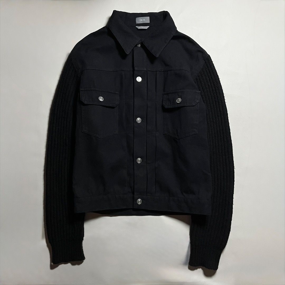 Authentic Dior Black Denim Jacket with Knit Sleeves (Category: Coats, Jackets and Outerwear) located in Caloocan City. Submitted by achilles_grails (Listing ID 1471078364, Image 1). Description: - 100% Authentic Dior black denim jacket, made in Italy - Unique ribbed knit black sleeves and collar - Button-up front with branded silver metal hardware - Two functional chest flap pockets - Large embroidered Dior logo on the back with a safety pin grap