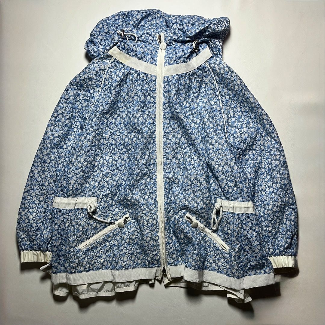 Authentic Moncler Eva Giubbotto Blue Floral Lace Jacket (Category: Coats, Jackets and Outerwear) located in Caloocan City. Submitted by achilles_grails (Listing ID 1471055121, Image 1). Description: - Brand: Moncler (Eva Giubbotto) - Color: Blue and white with delicate floral lace overlay - Features: Full zip closure with dual sliders, drawstring hood, and white contrast trim - Authenticity: Industries tag and internal hologram authentication lab