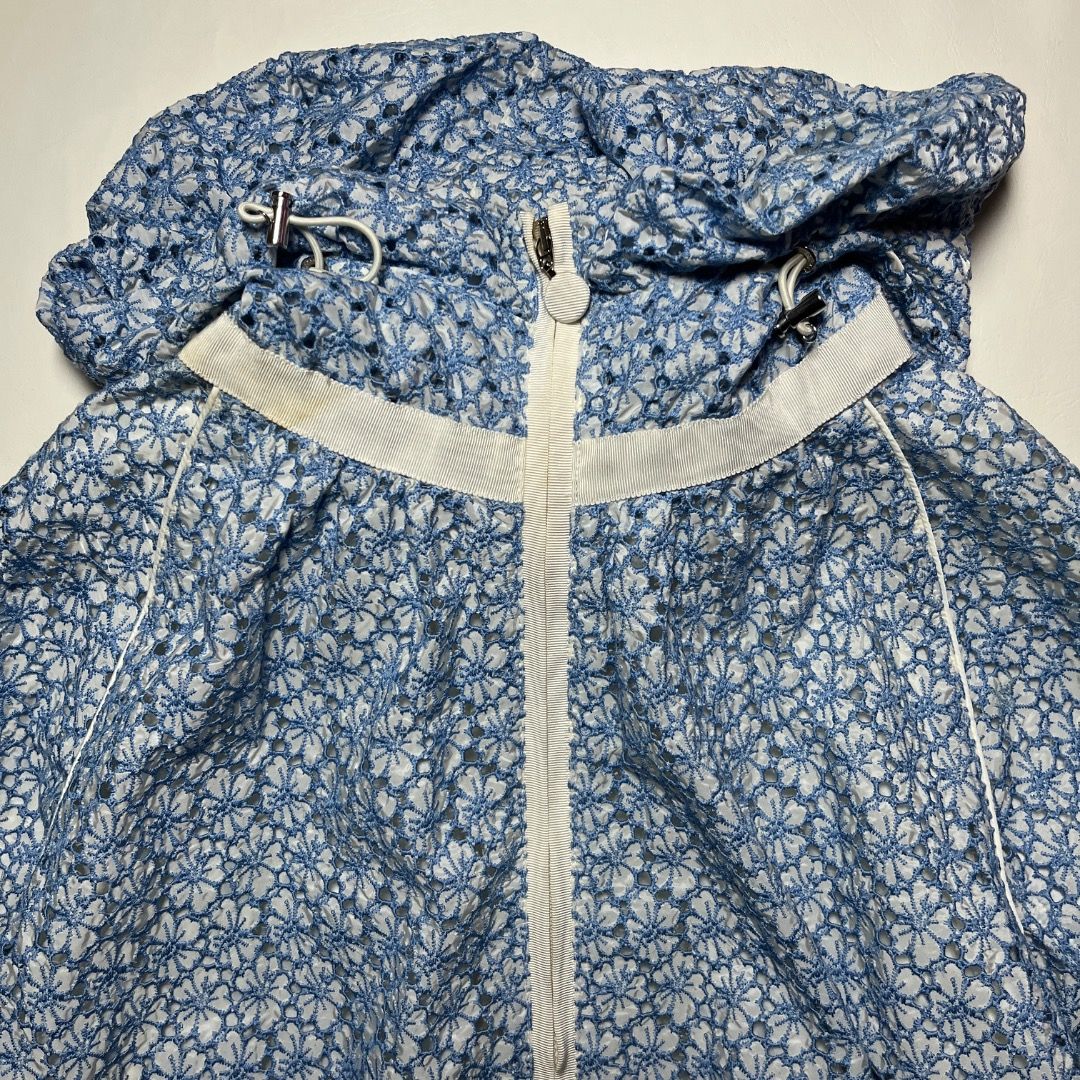 Authentic Moncler Eva Giubbotto Blue Floral Lace Jacket (Category: Coats, Jackets and Outerwear) located in Caloocan City. Submitted by achilles_grails (Listing ID 1471055121, Image 2). Description: - Brand: Moncler (Eva Giubbotto) - Color: Blue and white with delicate floral lace overlay - Features: Full zip closure with dual sliders, drawstring hood, and white contrast trim - Authenticity: Industries tag and internal hologram authentication lab
