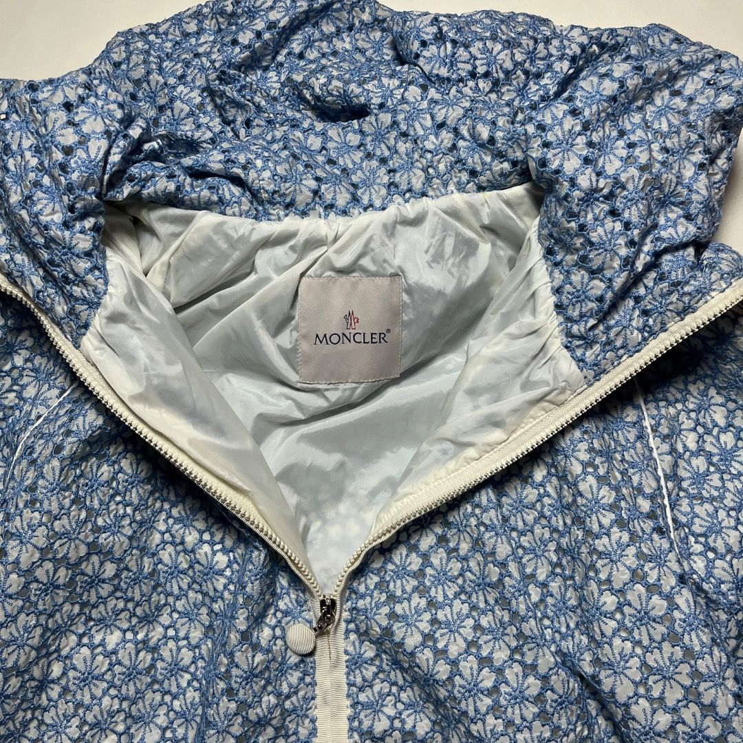 Authentic Moncler Eva Giubbotto Blue Floral Lace Jacket (Category: Coats, Jackets and Outerwear) located in Caloocan City. Submitted by achilles_grails (Listing ID 1471055121, Image 3). Description: - Brand: Moncler (Eva Giubbotto) - Color: Blue and white with delicate floral lace overlay - Features: Full zip closure with dual sliders, drawstring hood, and white contrast trim - Authenticity: Industries tag and internal hologram authentication lab